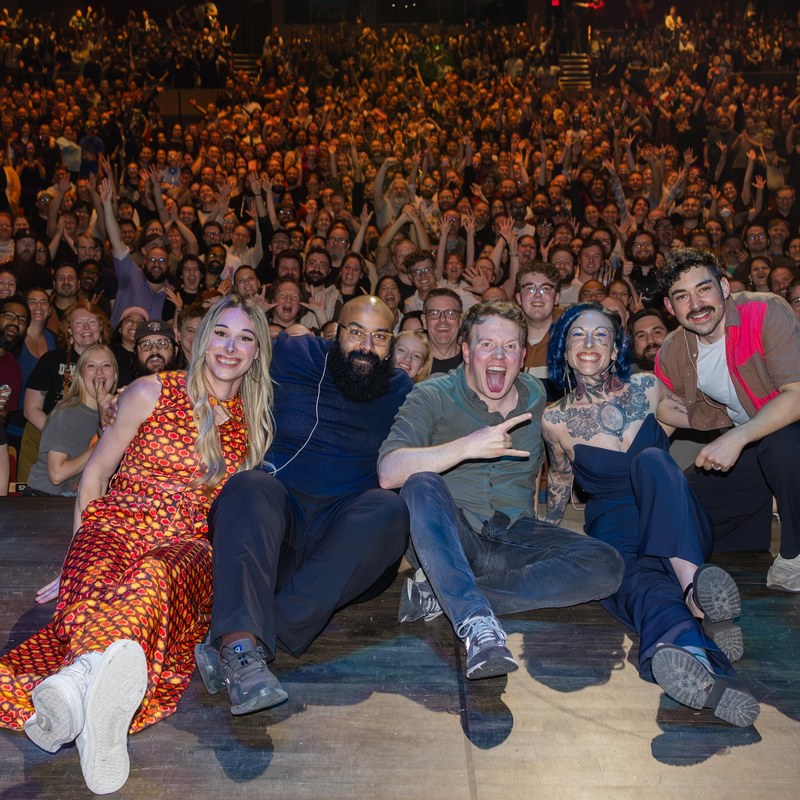 The Endless Dungeon cast, including Jess Lupini, on stage in front of a full house at the Queen Elizabeth Theatre